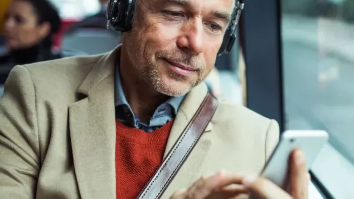 a man wearing headphones and holding a cell phone at The Hudson Oaks