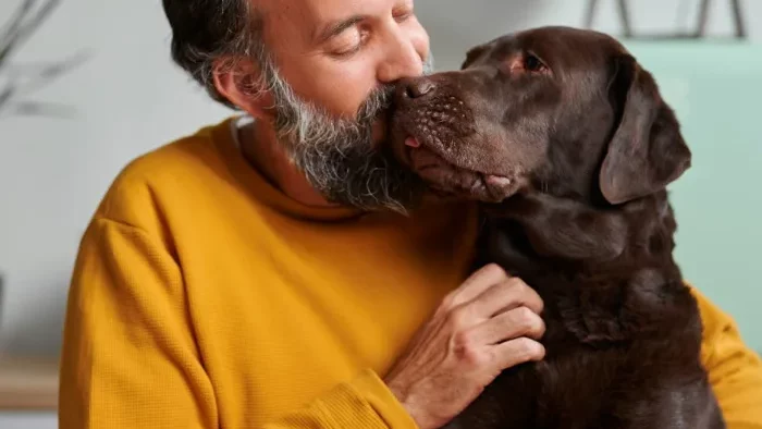 a man with a beard is kissing his dog at The Hudson Oaks