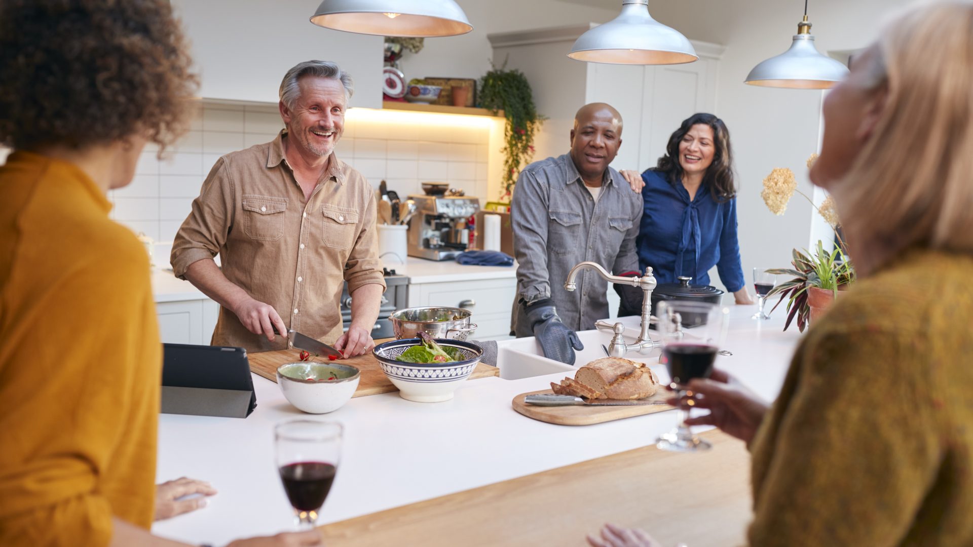 a group of people standing around a kitchen table at The Hudson Oaks