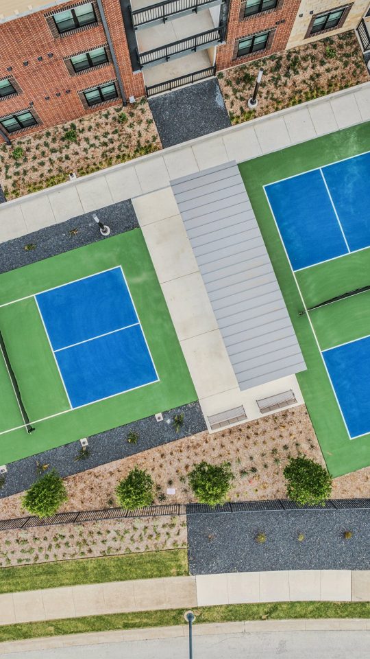 an aerial view of a tennis court and a building at The Hudson Oaks