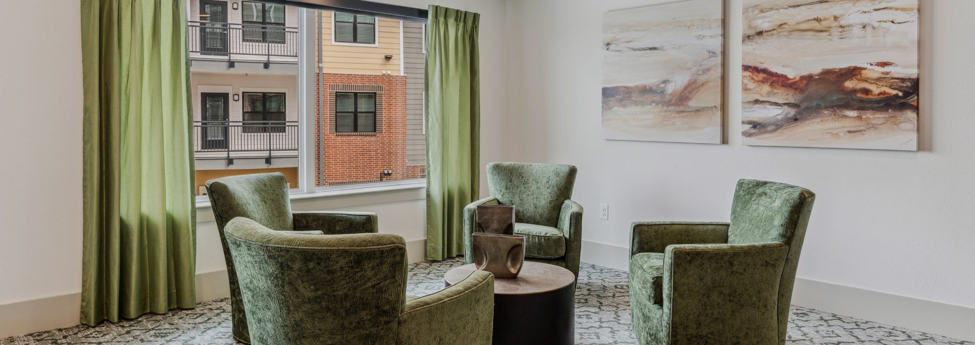 a living room with green chairs and a window at The Hudson Oaks
